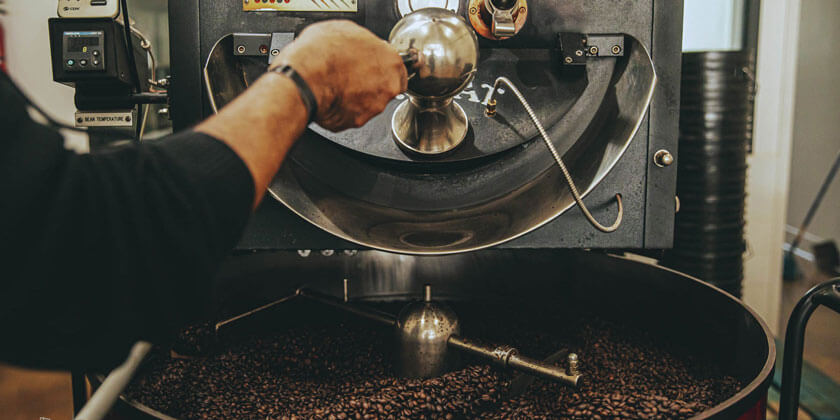 Specialty coffee single blend coffee being deposited from a roasting machine that has been created a masterful coffee with amazing taste provided by Black Stallion Coffee company 